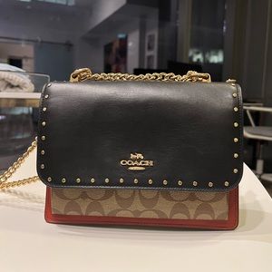 Coach crossbody with gold hardware and studs.